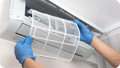 A filter being removed from a wall mounts unit by gloved hands